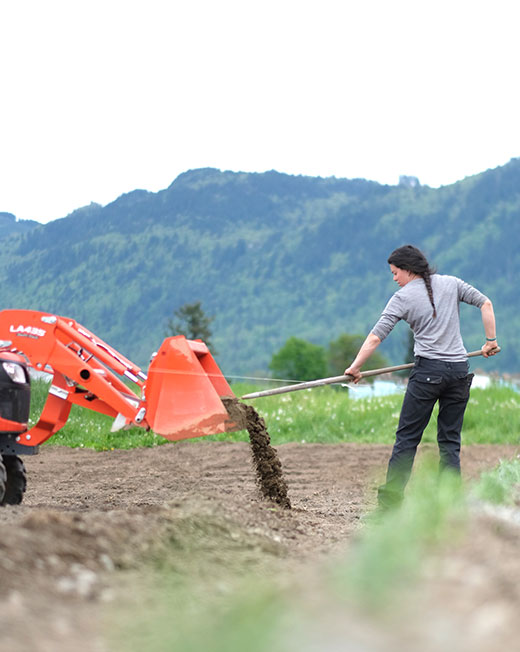 woman unloading soil from a tractor