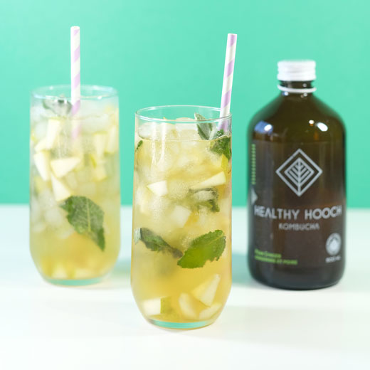 pear ginger mojito mocktails next to a bottle of healthy hooch kombucha